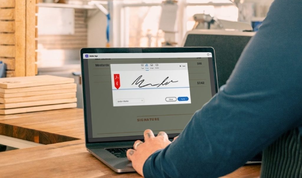 Adobe Sign software in use on a laptop on a kitchen counter